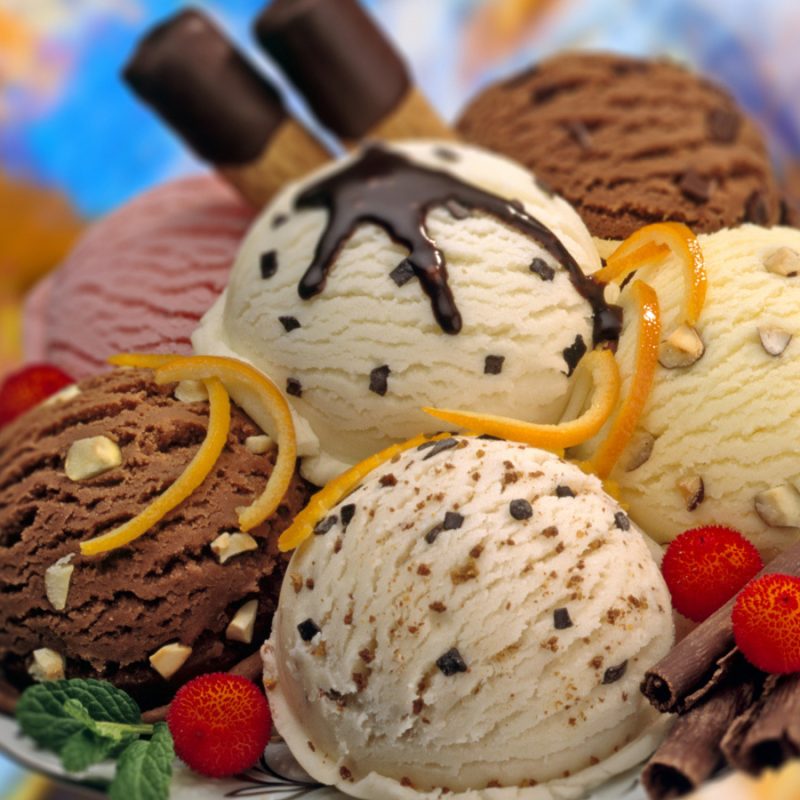 A composition of various flavours ice cream balls decorated with red fruits,chocolate curls and mint